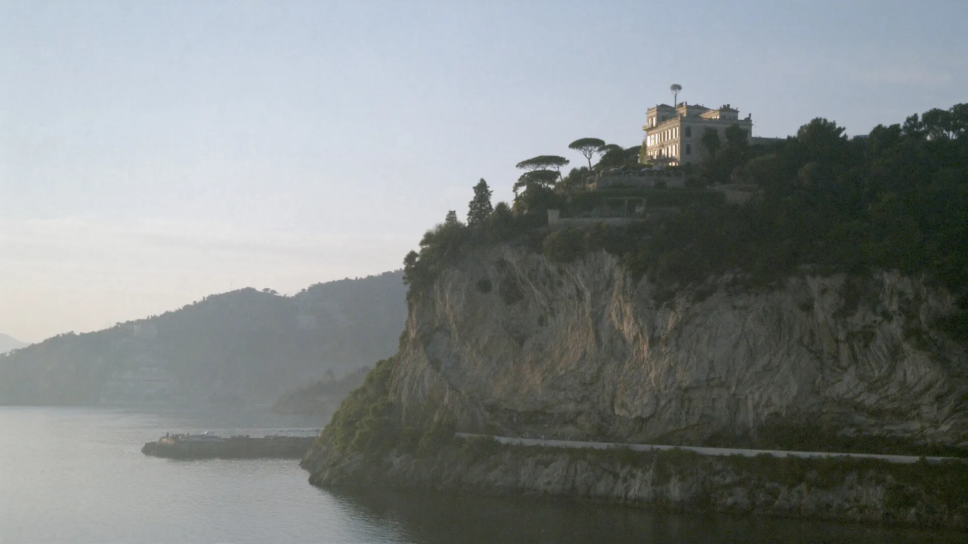 Italian coastline cliff with a historic villa at dawn